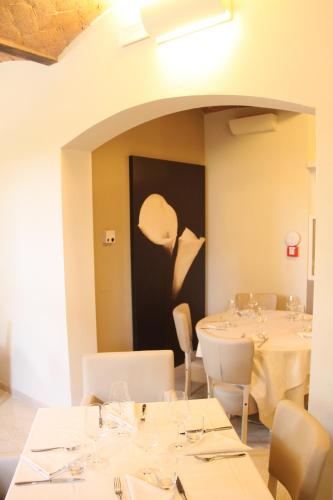 a dining room with white tables and white chairs at Hotel Villa Maranello in Maranello