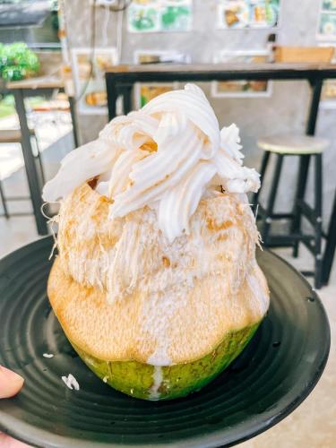 a donut with whipped cream on top on a green plate at Mateoasis in Ko Kood