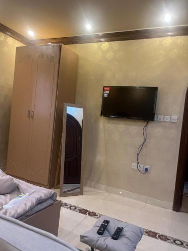 a room with a tv on the wall and a mirror at دار هند شقق مفروشة بحي سكني in Al Madinah