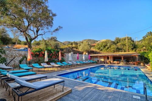 a swimming pool with chaise lounge chairs and a resort at Hotel Villa Marie in Sivota