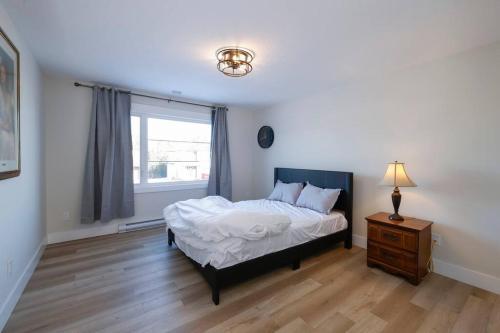 a bedroom with a bed and a dresser and a window at Luxury Room in a House. in Moncton