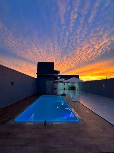 a swimming pool on top of a building with a sunset at LAR Espaço Lazer in Foz do Iguaçu