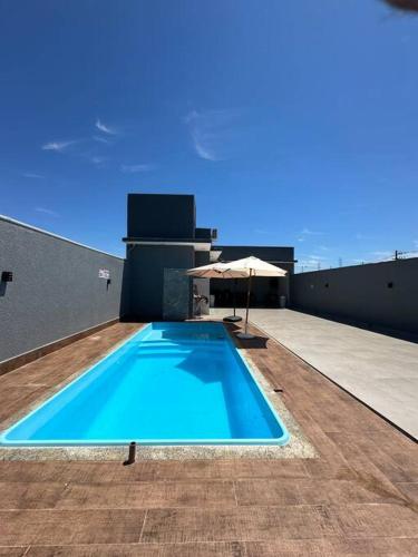 a swimming pool on top of a building with an umbrella at LAR Espaço Lazer in Foz do Iguaçu