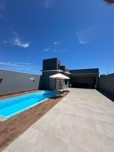 a swimming pool with an umbrella on top of a building at LAR Espaço Lazer in Foz do Iguaçu