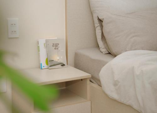 a book sitting on a table next to a bed at Lá Homestay in Mỹ Phước