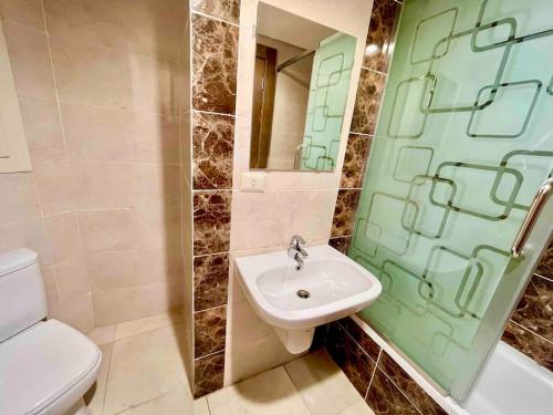開羅的住宿－UNIQue 2BRs LOCation l DOWNTown NEWCairo/City view，一间带水槽、卫生间和镜子的浴室
