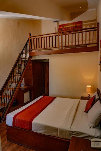 a bedroom with a bed and a staircase at Hotel Puri Dibia Kuta in Kuta