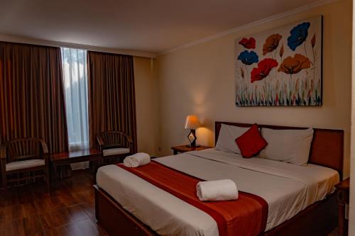 a hotel room with a large bed and a window at PURI DIBIA HOTEL in Kuta