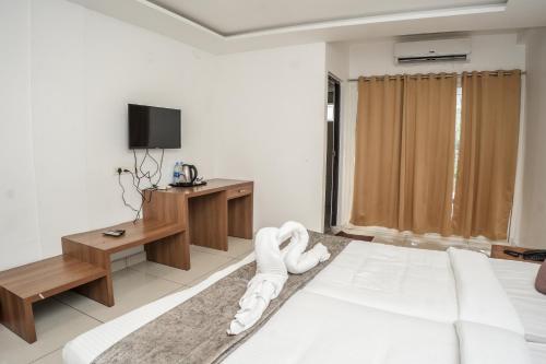 pokój hotelowy z łóżkiem i telewizorem w obiekcie HOTEL LETS STAY w mieście Ernakulam