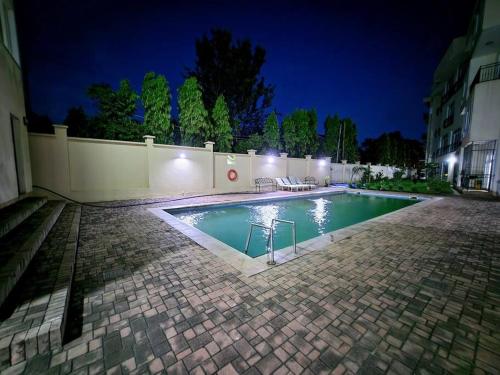 - une piscine dans une cour la nuit dans l'établissement Apartment in a Gated Community, à Arusha