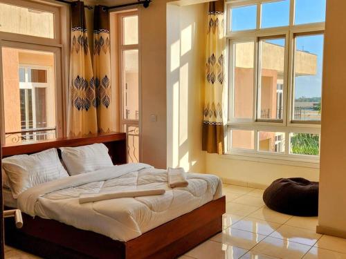 - une chambre avec un lit dans une pièce dotée de fenêtres dans l'établissement Apartment in a Gated Community, à Arusha