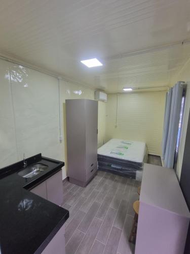 a small kitchen with a bed in a room at Vila Verde Container BV in Barra Velha
