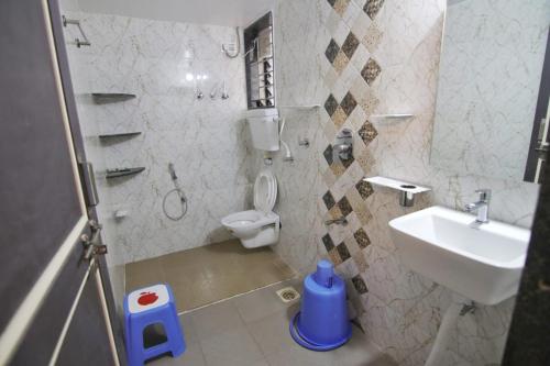 a bathroom with a toilet and a sink at Picaddle Serviced Apartment in Belgaum