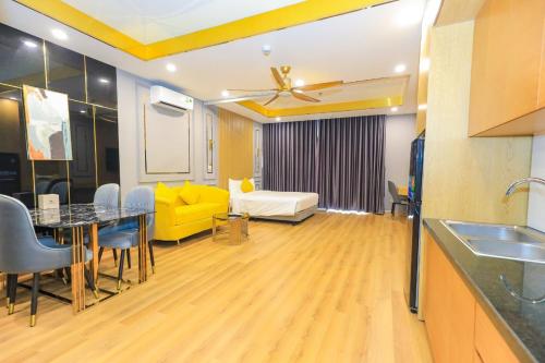ein Wohnzimmer mit einem Tisch und einem gelben Sofa in der Unterkunft TMS Quy Nhơn - Lee Xinh in Quy Nhon