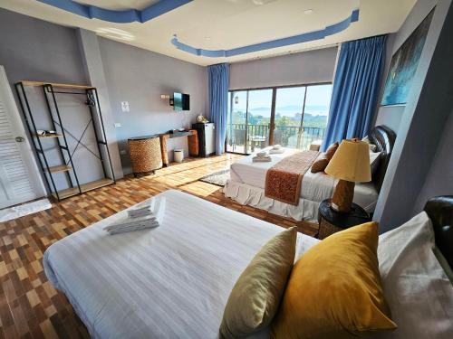 a hotel room with two beds and a large window at So View Phuket Resort in Ban Sam Kong