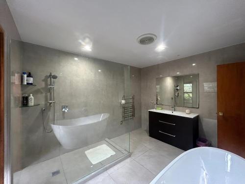 a bathroom with a tub and a sink at Rosie's Farmhouse in Pukekohe East