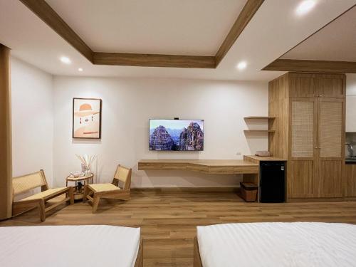 1 dormitorio con 2 camas y TV en la pared en TMS Quy Nhơn - Lee Xinh, en Quy Nhon