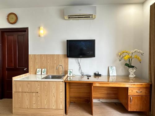 a kitchen with a sink and a tv on the wall at NEW LAND Apartment 2 - Phu My Hung in Ho Chi Minh City
