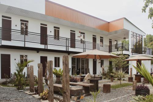 a building with benches and umbrellas in front of it at Alicia's Guest House in Butuan