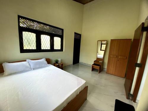 a bedroom with a large white bed and a window at Kaaya Villa @ Thalawathugoda in Colombo