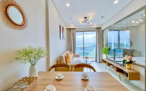sala de estar con mesa, sillas y espejo en The Song Vita's Apartment, en Vung Tau