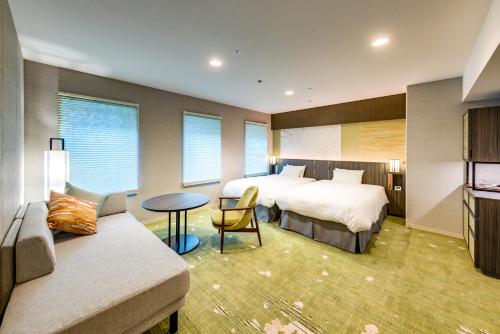 a hotel room with two beds and a couch at Miyako City Kintetsu Kyoto Station in Kyoto