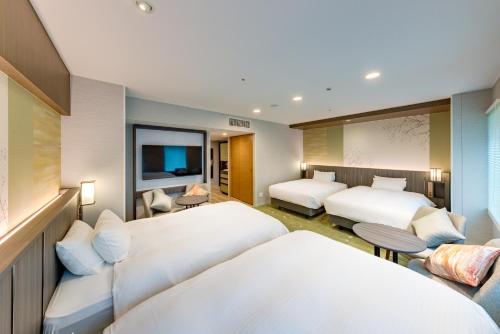 um quarto de hotel com duas camas e uma televisão em Miyako City Kintetsu Kyoto Station em Quioto