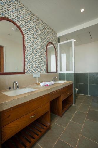 a bathroom with a sink and a large mirror at SaffronStays Athaang, Dapoli in Ānjarle
