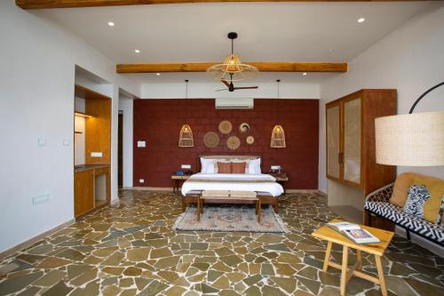 a bedroom with a bed and a couch at SaffronStays Athaang, Dapoli in Ānjarle