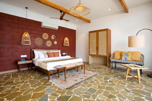 a bedroom with a bed and a table in a room at SaffronStays Athaang, Dapoli in Ānjarle