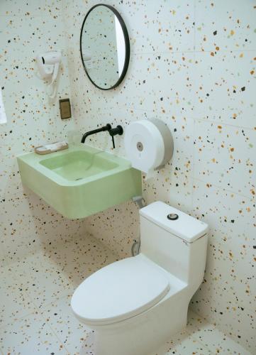a bathroom with a toilet and a sink and a mirror at Lá Homestay in Mỹ Phước