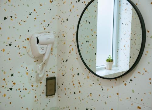 a mirror in a bathroom with a hair dryer at Lá Homestay in Mỹ Phước