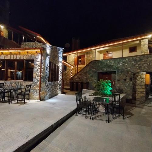 an outdoor patio at night with a table and chairs at Exohiko in Palaios Agios Athanasios
