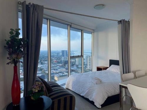 a bedroom with a bed and a large window at Skyline and Mountain View CBD Stay in Gold Coast