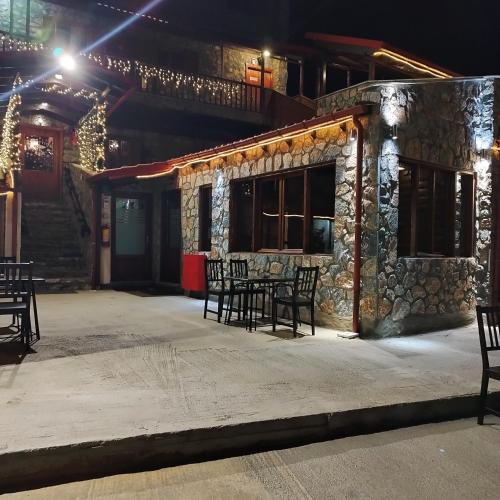 a table and chairs outside of a building at night at Exohiko in Palaios Agios Athanasios