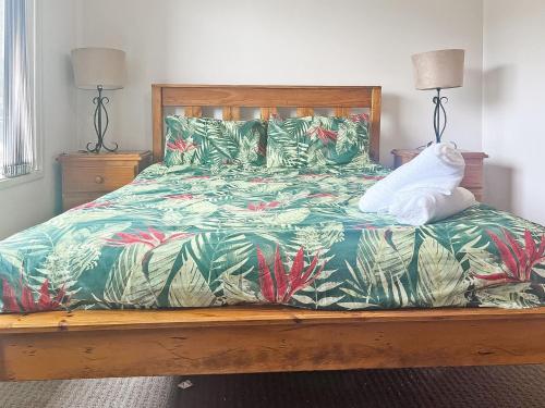 a bedroom with a bed with a tropical bedspread at Northward Unit 1 1 2 Magnus St Nelson Bay in Nelson Bay
