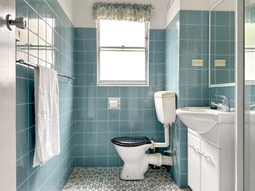 a bathroom with a toilet and a sink at Northward Unit 1 1 2 Magnus St Nelson Bay in Nelson Bay