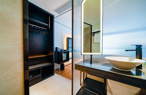 a bathroom with a sink and a mirror at Pengke Boutique Hotel - Sungang Sunway Station in Shenzhen
