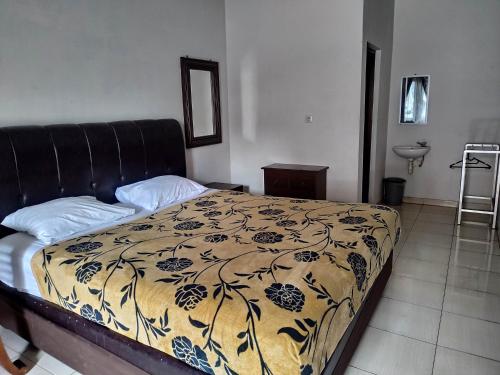 a bedroom with a bed with a black and white blanket at Tiara Puspita Laweyan Hotel in Grogol