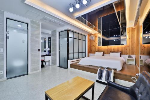 a bedroom with a bed and a desk in a room at G&G Hotel in Ulsan