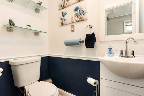 een badkamer met een wit toilet en een wastafel bij 3 bed/5 bath Small Party Space & Deck Smoking OK in Detroit
