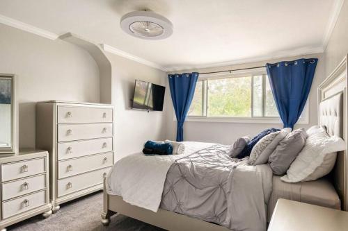 een slaapkamer met een bed met blauwe gordijnen en een dressoir bij 3 bed/5 bath Small Party Space & Deck Smoking OK in Detroit