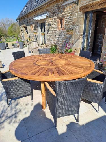 einen Holztisch mit Stühlen auf einer Terrasse in der Unterkunft la hamonniere in Savigny-le-Vieux