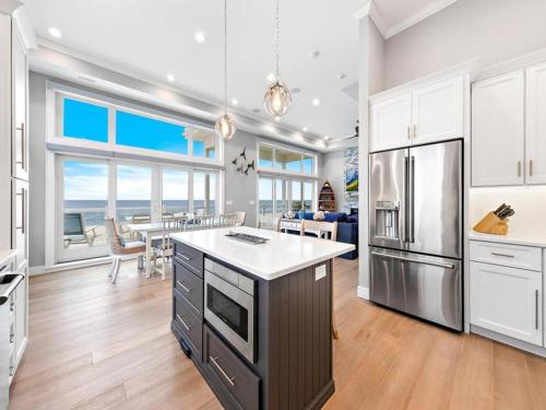 Il comprend une cuisine équipée d'un réfrigérateur et une salle à manger. dans l'établissement New Oceanfront In Peahala Park , Sleeps 11 ,, à Brant Beach