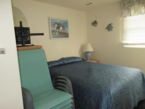 a bedroom with a blue bed and a chair at Immaculate 2Nd Floor Duplex In Brant Beach Located Just 3 Homes From The Beach in Brant Beach