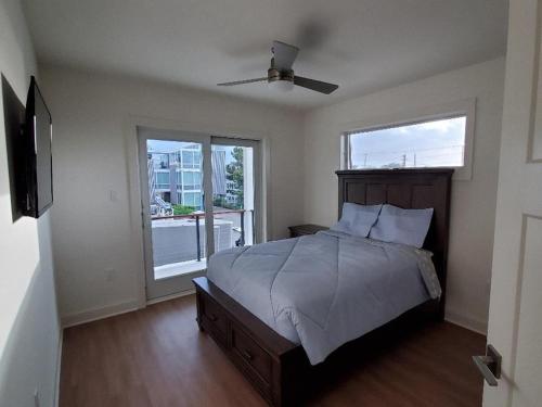 een slaapkamer met een bed, een ventilator en 2 ramen bij 3022 Casciaro in Harvey Cedars