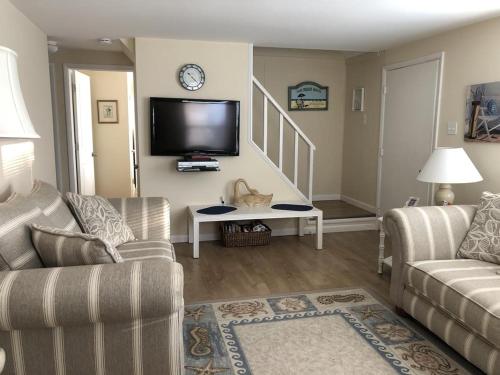 uma sala de estar com um sofá e uma televisão em Beachy Cape Cod Perfect For Families em Beach Haven