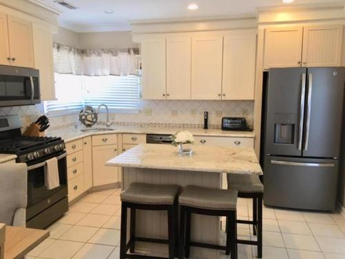 ビーチヘイブンにあるFabulous Condo With Bay Views!のキッチン(冷蔵庫付)、カウンター(スツール付)