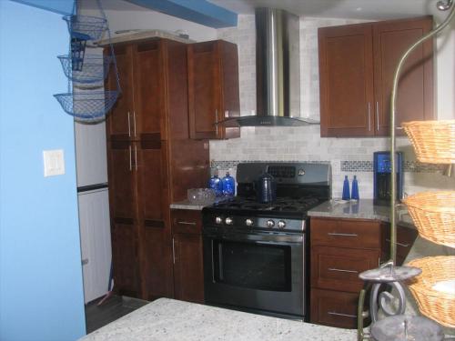 a kitchen with wooden cabinets and a stove top oven at Super Cute!! Waterfront Lagoon In Beach Haven West! in Manahawkin