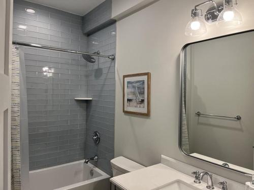 a bathroom with a tub and a sink and a mirror at Tastefully Decorated Condo in Ship Bottom